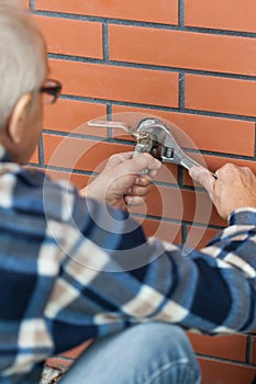 Elderly man screwed key tap