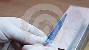 An elderly man sharpens a knife with a whetstone close-up