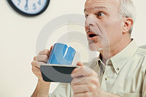 Elderly man shocked by smartphone in kitchen