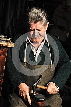 Elderly man, shoemaker repairing