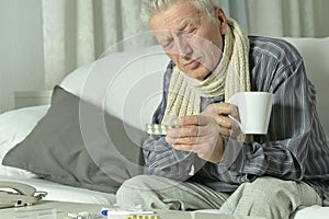 An elderly man is sick and drinks tea