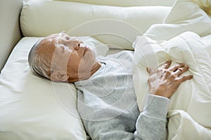 Elderly man sleeping on the bed