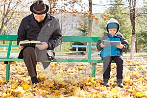 Elderly man and small boy sharing a park bench