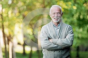 Elderly man smiling outdoors in nature