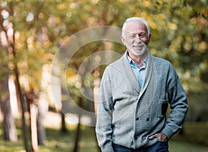 Elderly man smiling outdoors in nature