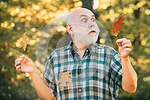 Elderly man smiling outdoors in nature. Portrait of a senior man outdoors walking in a park. Portrait of handsome old