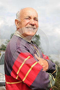 An elderly man smiling in the sun