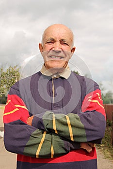 An elderly man smiling in the sun