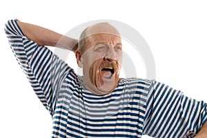 Elderly man in a stripped vest yawns