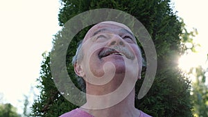 elderly man in a summer park dreaming looking around on summer day