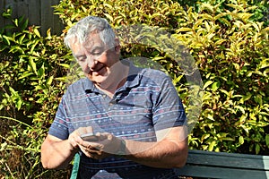 Elderly man texting on his mobile phone.