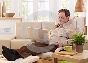 Elderly man using laptop computer