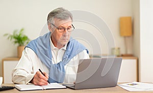 Elderly Man Using Laptop Working In Modern Office