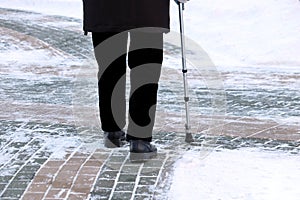 Elderly man with walking cane on a winter street