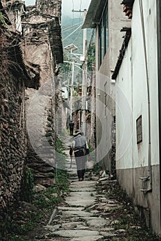 Elderly man walking on a deserted, rural road in Southern China