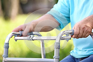 Elderly man with walking frame outdoors. Medical help
