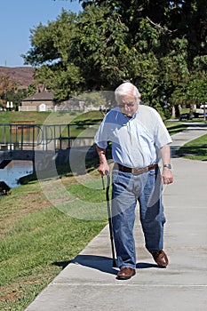 Elderly man walks with a cane photo