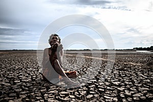 An elderly man was sitting asking for rain in the dry season, global warming, selective focus