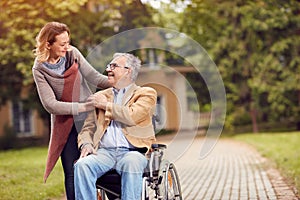 Elderly man in wheelchair with her daughter enjoying to visit to