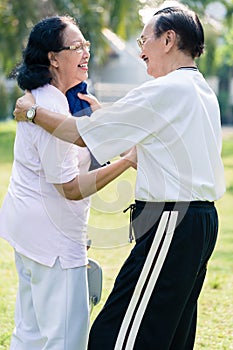 An elderly man wipe the sweat from his wife`s face with towel