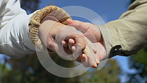 Elderly man and woman holding hands, aged couple romantic date, love closeness