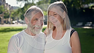 Elderly Man And Woman In Park After Fitness Talk And Have Fun. They Smile. Gray Haired Man With Beard And Woman With