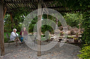 Elderly man and woman sitting in their yard