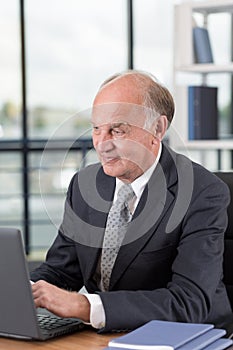 Elderly man working on laptop