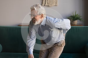 Elderly man writhes in pain suffers from low back strain photo