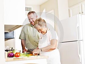 Elderly married couple cooking dinner