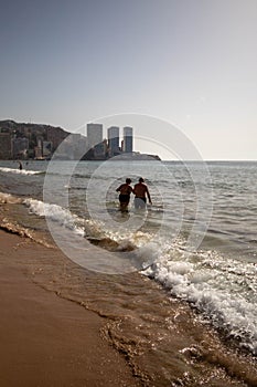 Elderly married couple enjoying their last days taking a bath in the Benidorm Mediterranean Sea whil