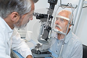 Elderly man with glaucoma at optician for optical examination photo