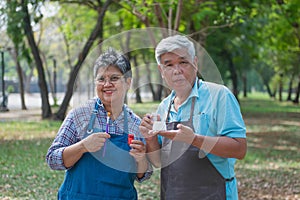 Elderly men and women doing activities in the park Use a paintbrush to paint pottery