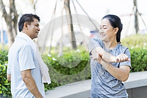 Elderly men and women exercising in the park. Senior Couple Doing Fitness Exercise In Park