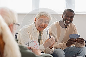 Elderly multiethnic men playing cards with