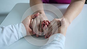 Elderly nurse holds the young patient`s hands after injecting the vaccine for COVID-19.