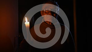 elderly old man gray-haired in glasses sight holding lit candle fire hands