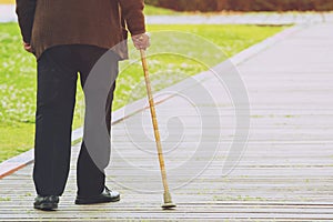 Elderly old man with walking stick stand waiting on footpath sidewalk crossing