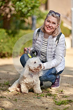 Elderly pensioner woman walk park white small dog