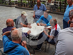 ACITREZZA, ITALY, CIRCA AUGUST 2021 elderly pensioners play cards on the street after lockdown due to covid-19
