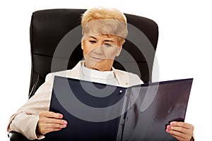 Elderly pensive focused business woman reading notes