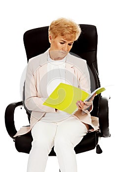 Elderly pensive focused business woman reading notes