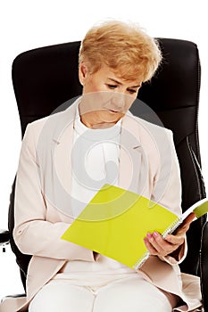 Elderly pensive focused business woman reading notes