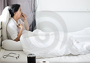 Elderly people asian woman coughing and sitting on her bed,Female sore throat,Concept of health