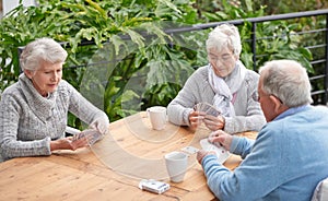 Elderly people, card games and coffee at table with outdoor background for retirement and old age. Group, seniors or