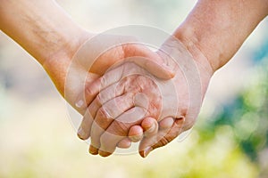 Elderly people care concept, young female hands holding wrinkled hand of senior woman