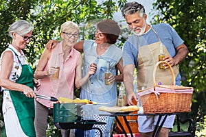 Elderly people celebrate the 4th of July by making barbeque in their backyard