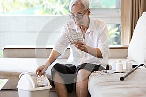 Elderly people is checking expiration date or deterioration of medication before use in the treatment,senior woman reading pill photo