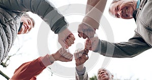 Elderly people, fist bump and fitness in team motivation or support in outdoor unity at old age home. Senior group hands