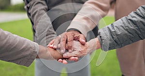 Elderly people, hands together and fitness in team motivation or support in outdoor unity at old age home. Closeup of